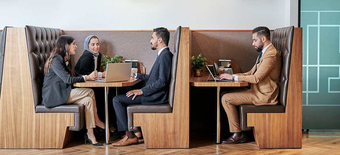 Clients working and networking in a collaborative booth at Doha’s top coworking space.